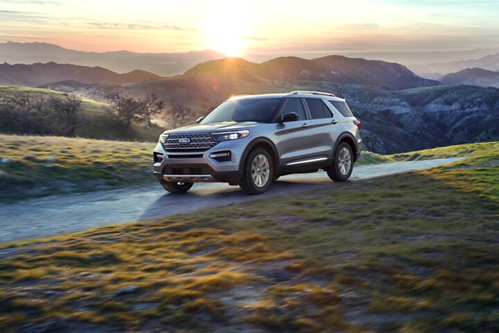 La SUV Ford Explorer® 2023 en Iconic Silver Metallic circulando entre las montañas al atardecer