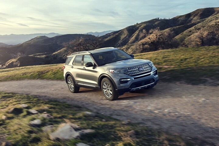 El modelo Ford Explorer® Limited 2023 en Iconic Silver Metallic circulando por una carretera empinada con cerros de fondo