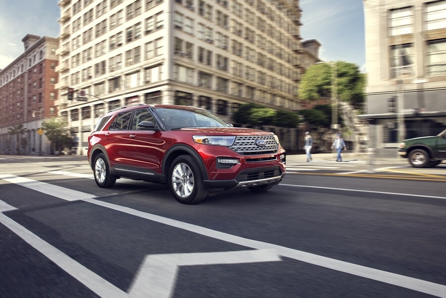 2023 Ford Explorer® Limited model in Rapid Red Metallic Tinted Clearcoat being driven down a city street