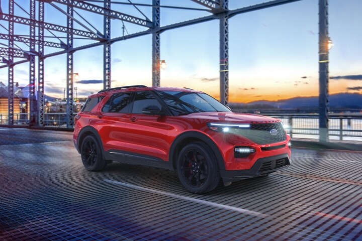 2023 Ford Explorer® ST model in Rapid Red Metallic Tinted Clearcoat being driven across a bridge