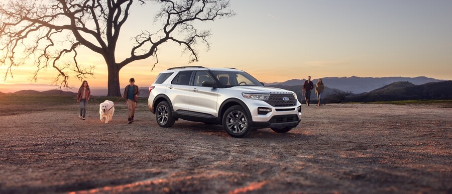 2023 Ford Explorer® XLT SUV parked in a field with family nearby
