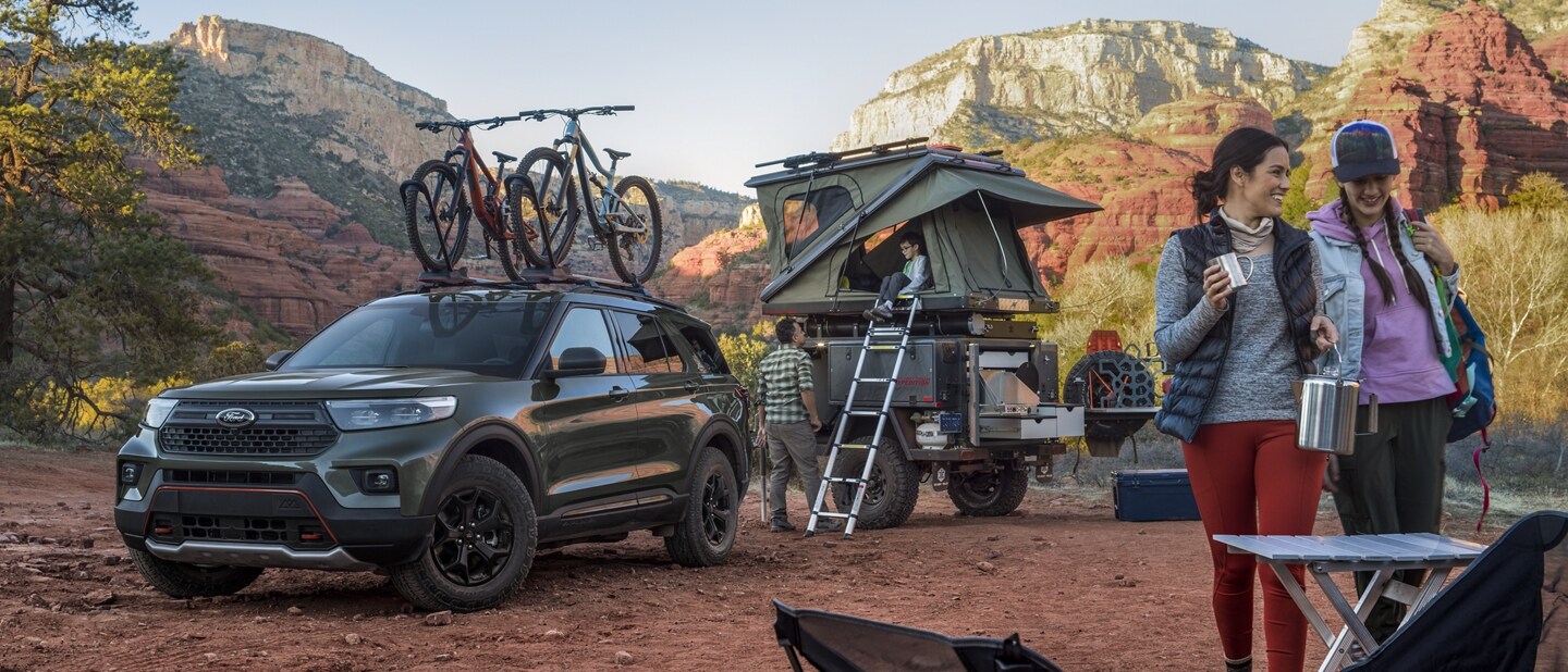 Una SUV Ford Explorer® Timberline® 2023 con una reja para bicicletas montada en el techo estacionada en un camping