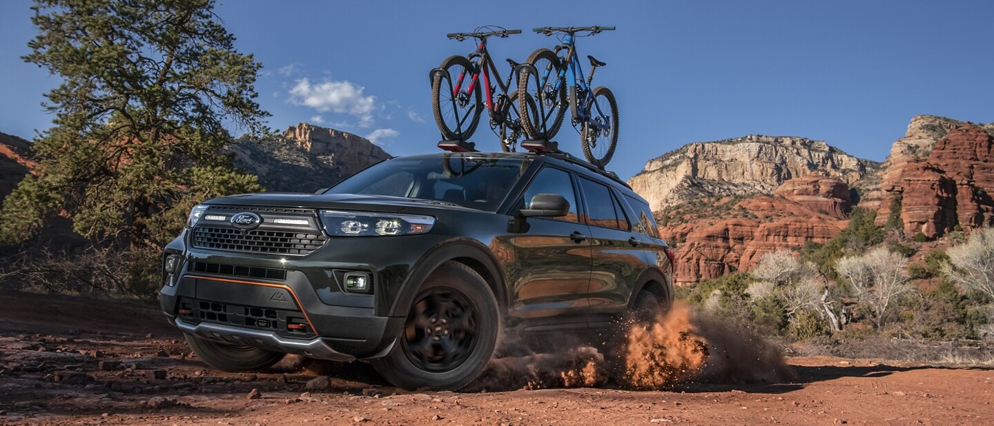 2023 Ford Explorer® Timberline® model being driven through the desert with bikes on the roof