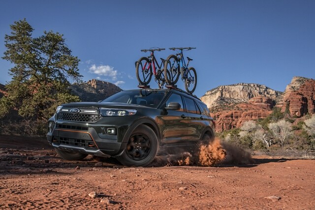 2023 Ford Explorer® Timberline® model being driven through the desert with bikes on the roof