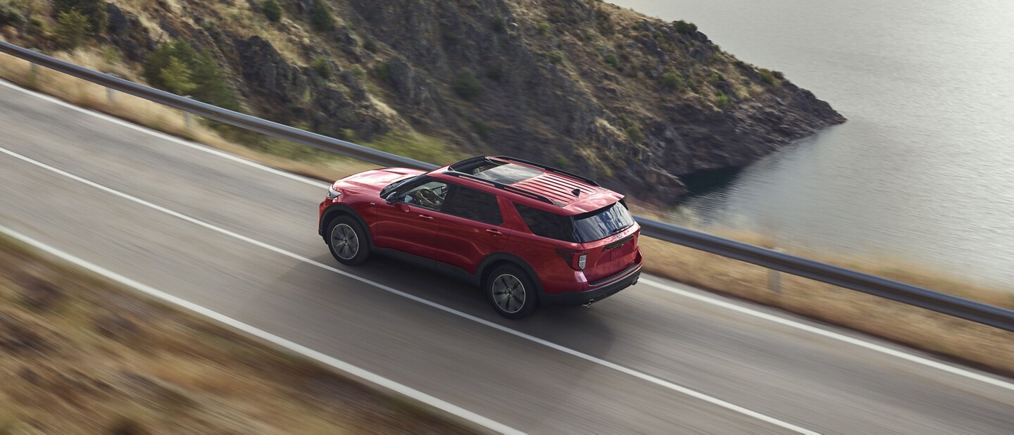 2023 Ford Explorer® ST Line model being driven on a lakeside highway