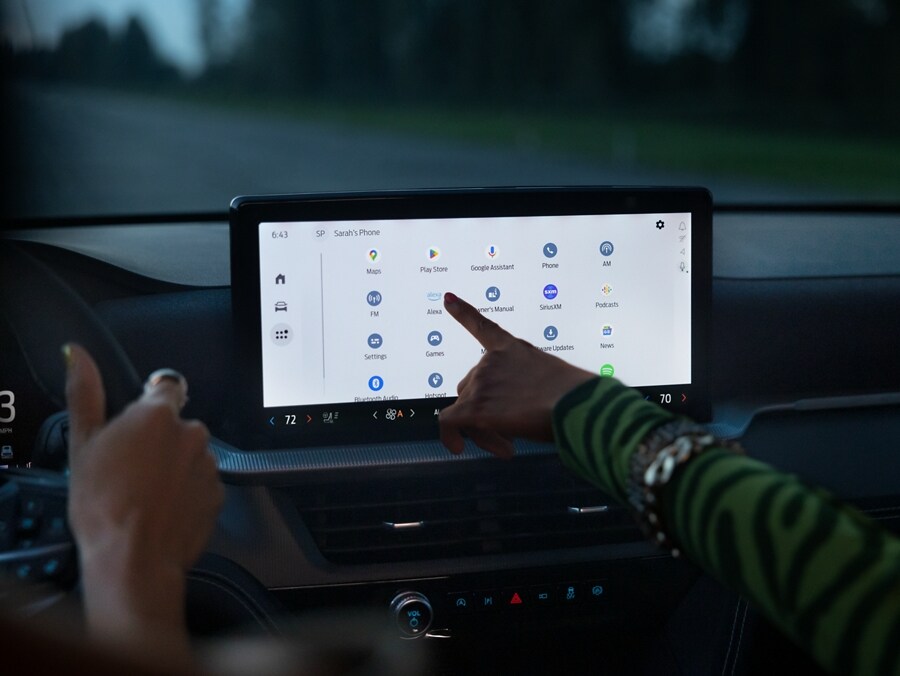  2025 Ford Explorer touchscreen with person pointing to application. 