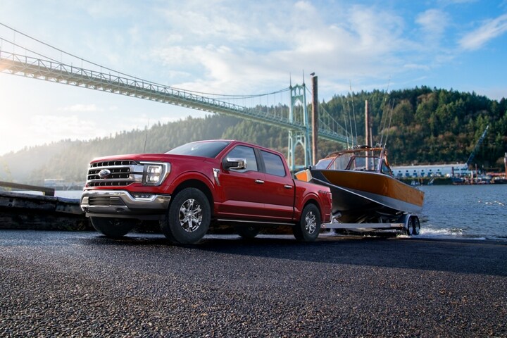 A 2023 Ford F-150® backing a boat into the water