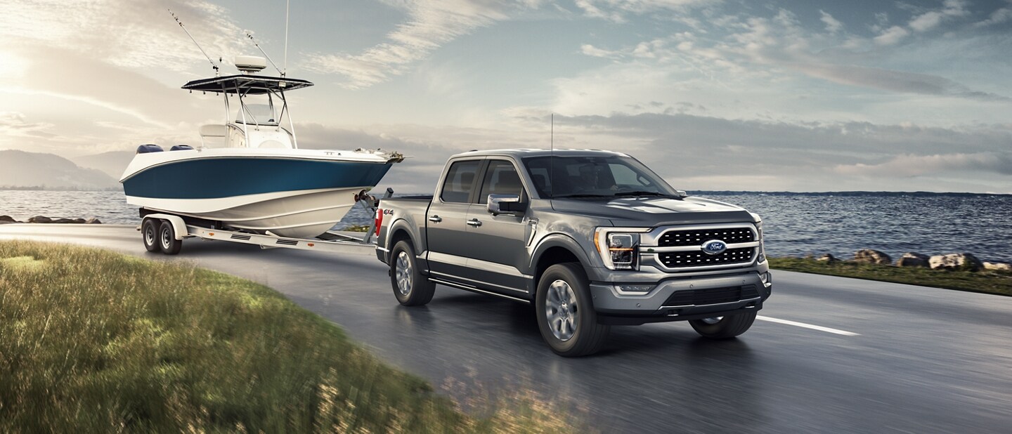 Una Ford F-150® 2023 remolcando un bote junto a un lago