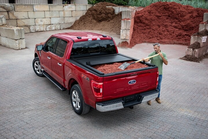 A man loading woodchips into the bed of a 2023 Ford F-150®