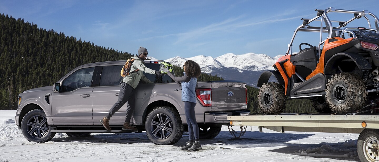 Una Ford F-150® 2023 remolcando un cuatriciclo en un tráiler