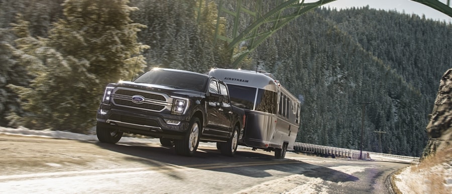 A 2023 Ford F-150® pulling an airstream camper on a mountain roadway