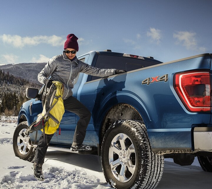 Woman using the side step to put gear into the truck bed