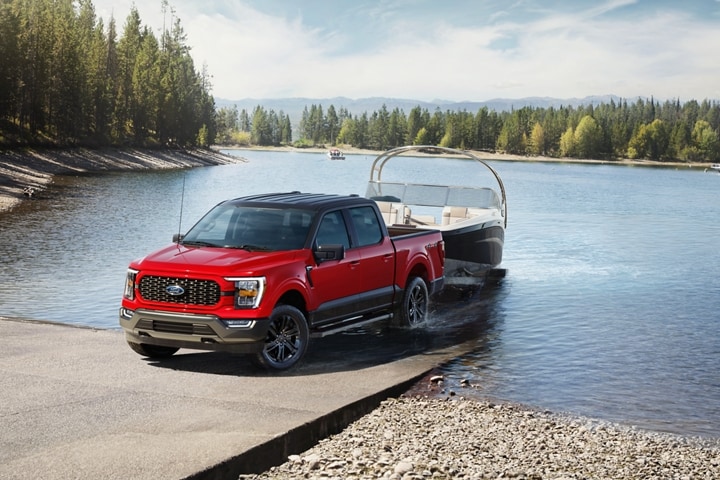 A 2023 Ford F-150® XLT Heritage Edition pickup is pulling a boat out of the water