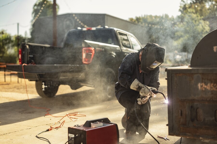 Worker using the Pro Power Onboard feature to power a welder