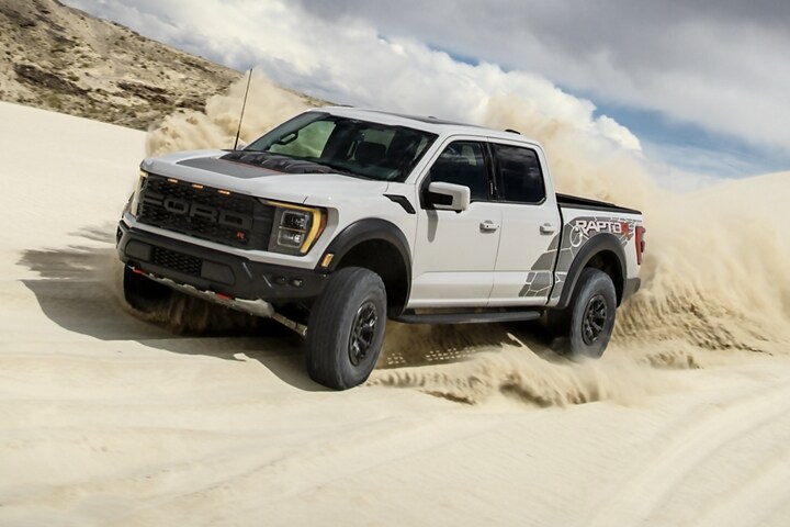 2023 Ford F-150® Raptor R™ being driven in the desert kicking up sand