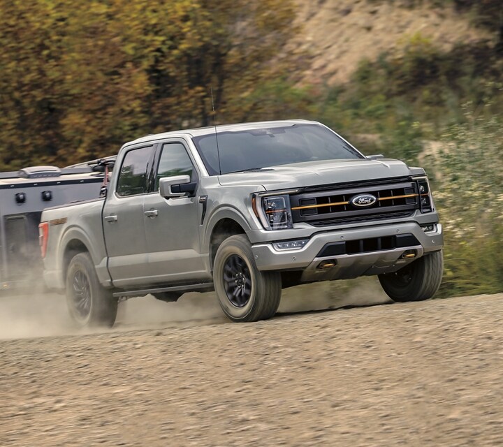 2023 Ford F-150® Tremor™ with Tow package driving down a dirt road