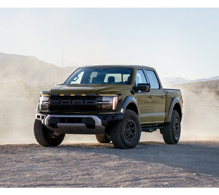 2024 Ford F-150® Raptor® being driven in the desert kicking up sand