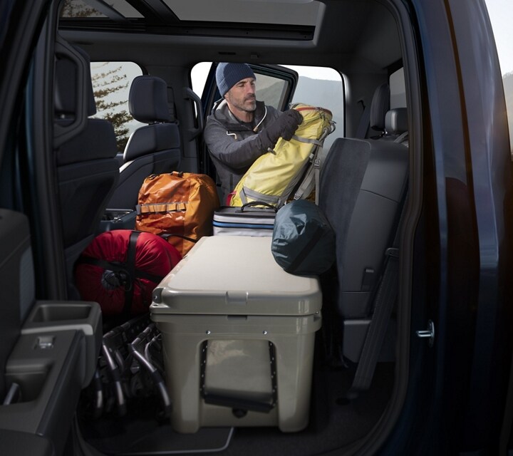 2024 Ford F-150® Interior showcasing the rear flat load floor with camping gear