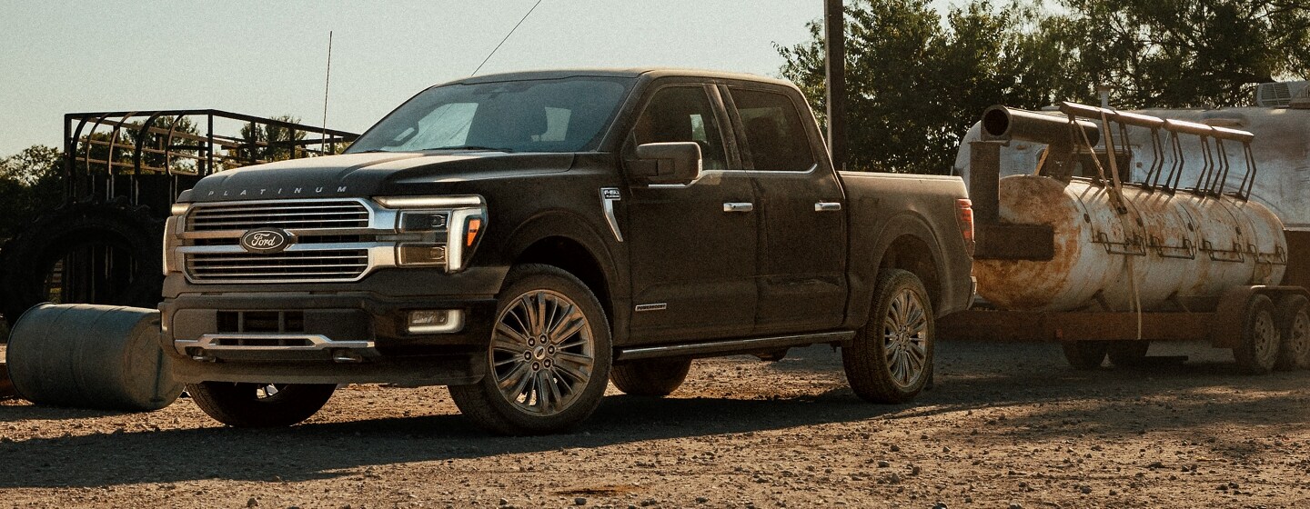 A 2024 Ford F-150® pickup pulling equipment through a dirt parking lot
