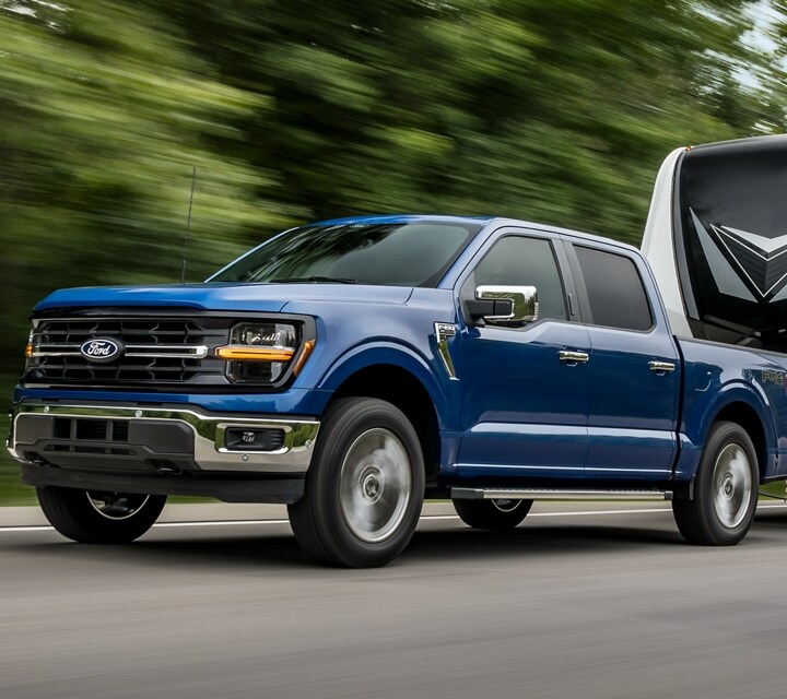 2024 Ford F-150® XLT in Atlas Blue pulling a camper trailer