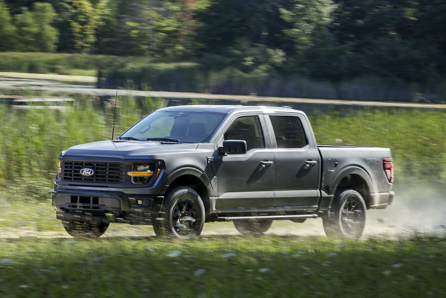  2024 Gray New designed Ford F-150 Gas powered pickup truck driving through fields on gravel path