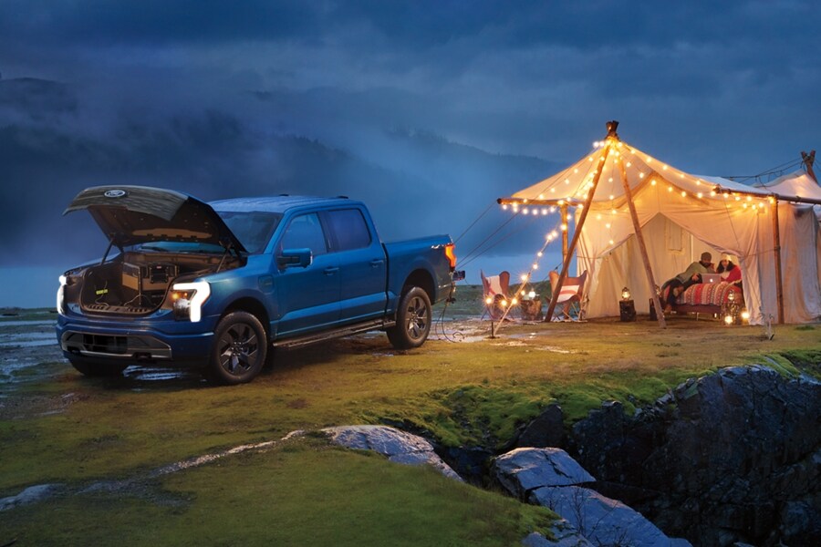 The Ford lightning being used to power strands of lights and a laptop for outdoor camping