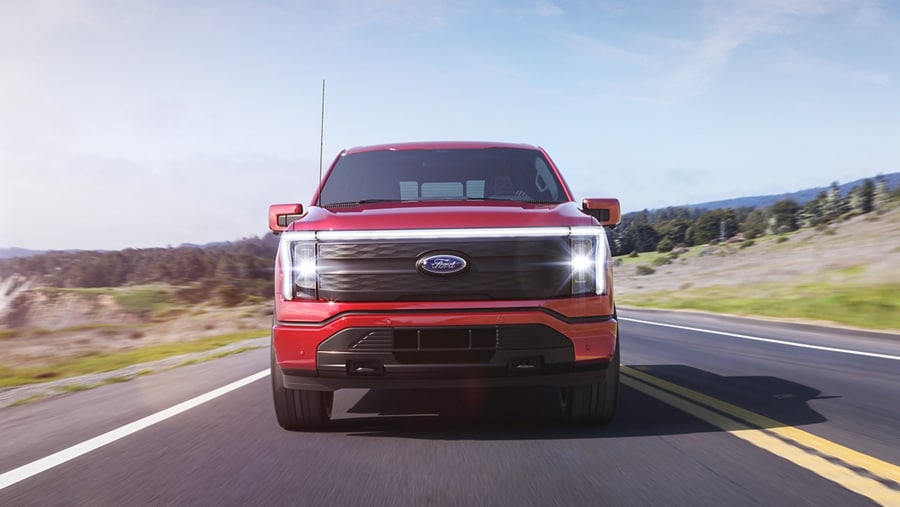 Straight-on shot of a 2023 Ford F-150 Lightning® driving on coastal road