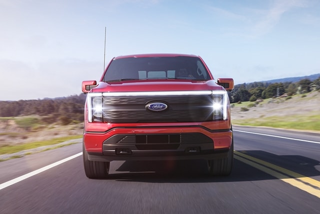 Straight-on shot of a 2023 Ford F-150 Lightning® driving on coastal road
