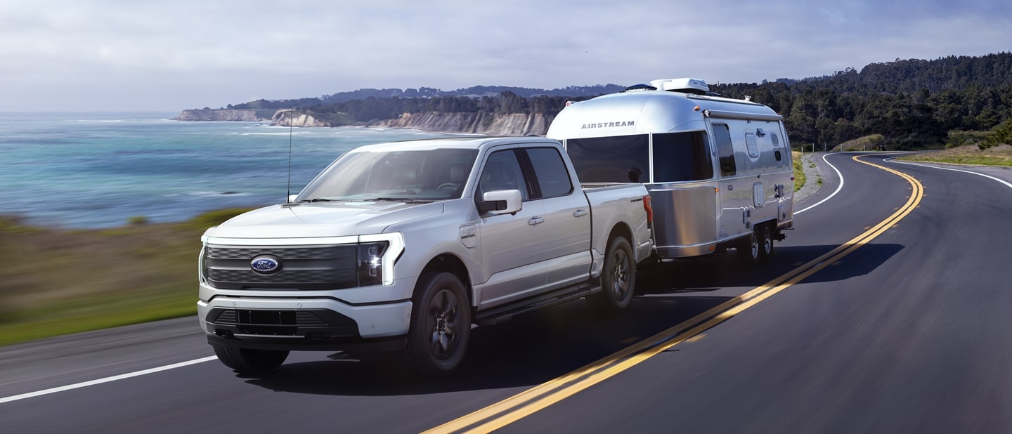 A 2023 Ford F-150 Lightning® towing an Airstream camping trailer