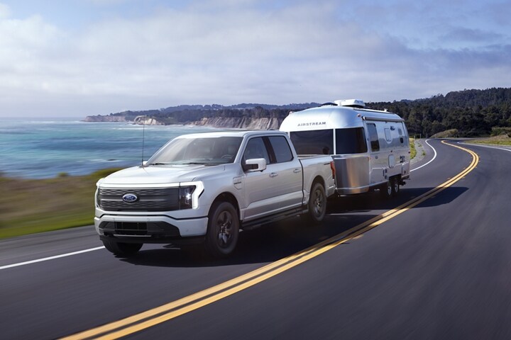 A 2023 Ford F-150 Lightning® pulling an Airstream camping trailer