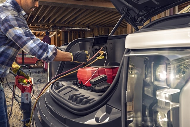 Close-up of man plugging in electric cords into Mega Power Frunk outlets