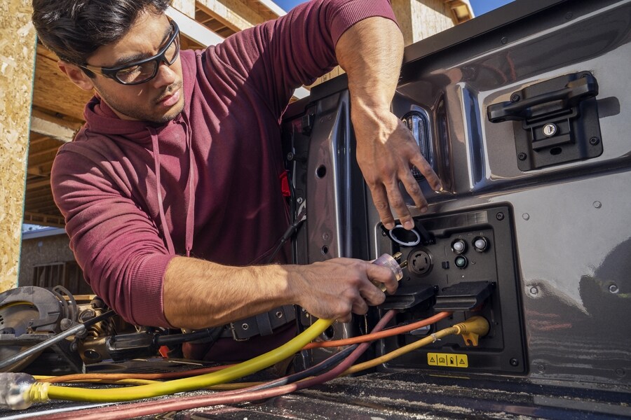 Close-up of man plugging in electric cords into side bed outlets