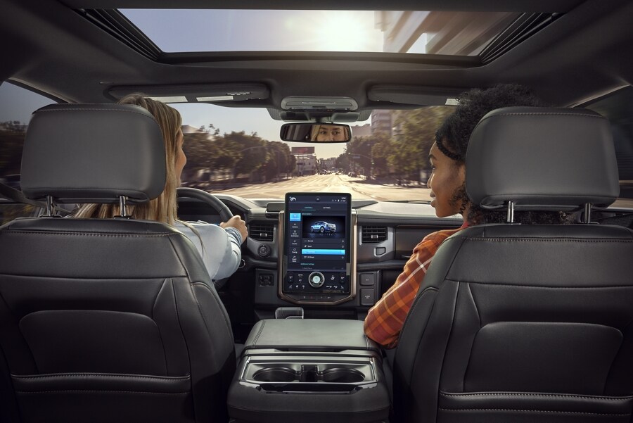 Interior photo from rear seat of the front dash as two women sit in front seats