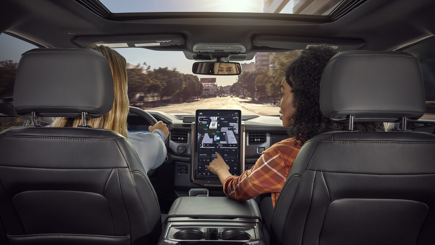 Interior shot as passenger interacts with touchscreen navigation