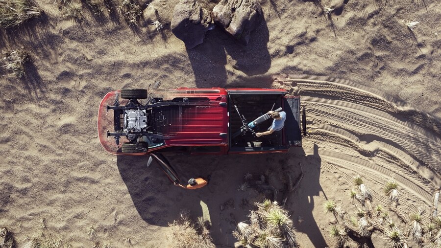 Overhead view of a 2023 Ford F-150 Lightning® in desert, people unloading recreation gear