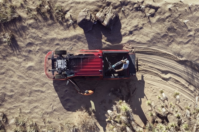 Vista superior de una Ford F-150 Lightning® 2023 en el desierto, con personas descargando equipos de recreación