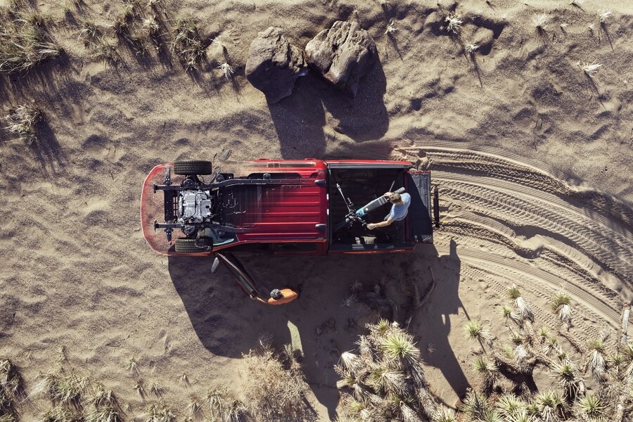 Extreme overhead shot of two cyclists in the desert getting out of their 2023 Ford F-150 Lightning