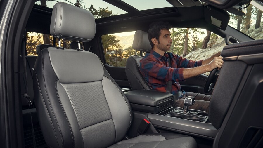 Interior shot of luxurious seating as we see man driving