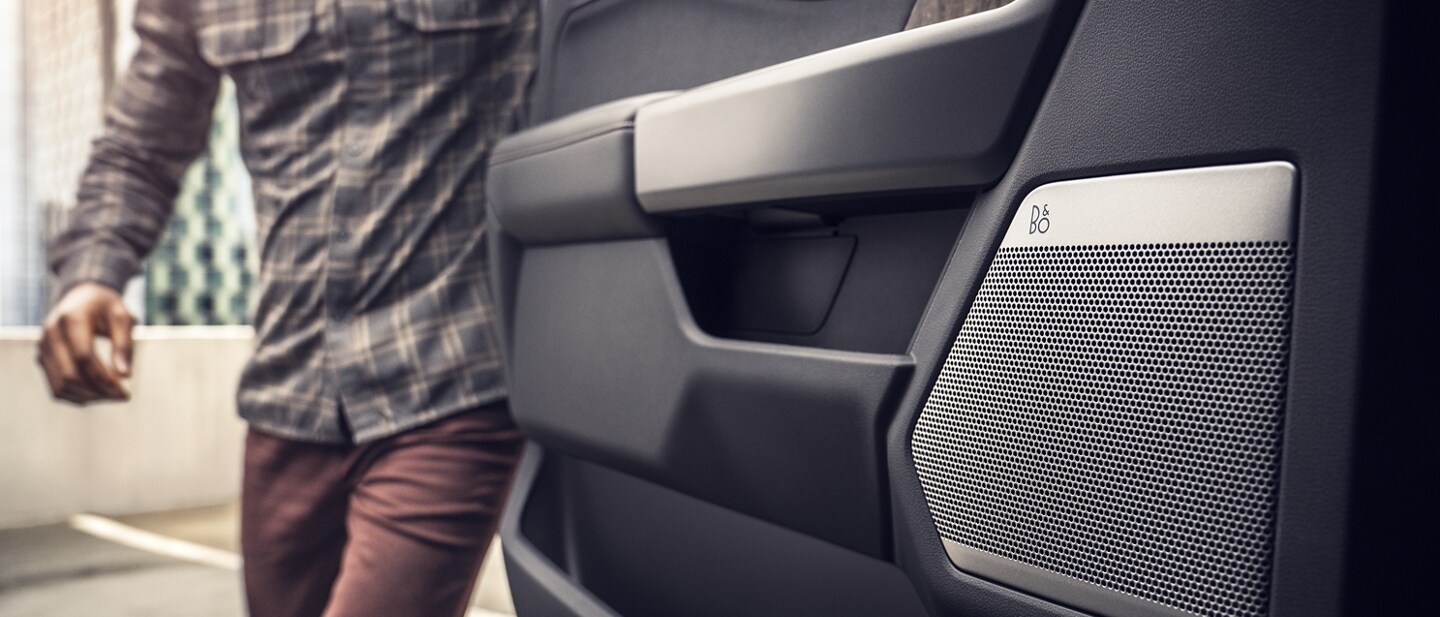 Interior door panel highlights the speaker as person opens door