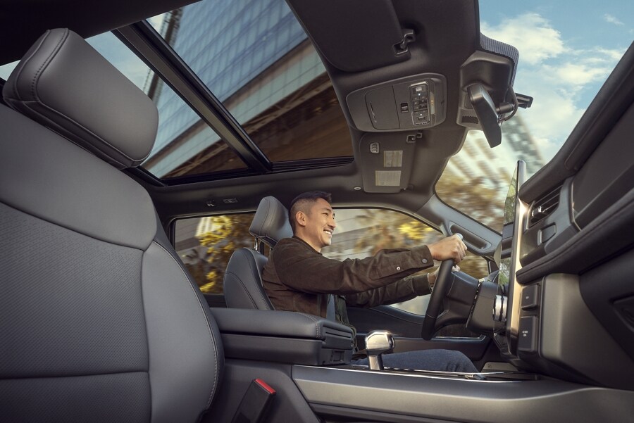 Interior of a 2023 Ford F-150 Lightning with smiling man driving