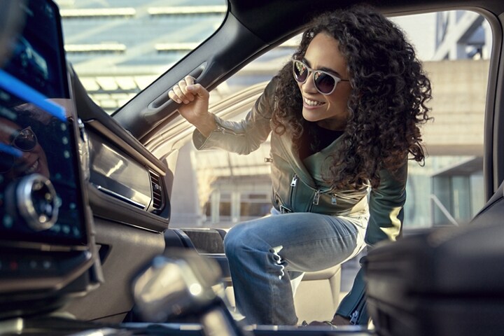 Woman using the grab handle to climb into the passenger side