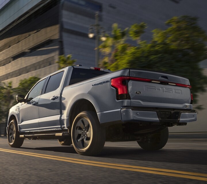 A 2023 Ford F-150 Lightning™ being driven down a city street