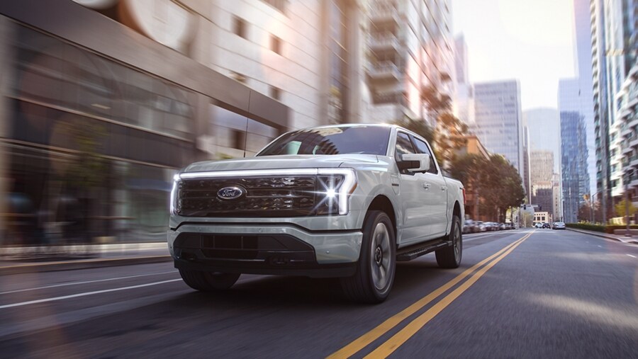 A 2023 Ford F-150 Lightning® Platinum edition being driven down a city street