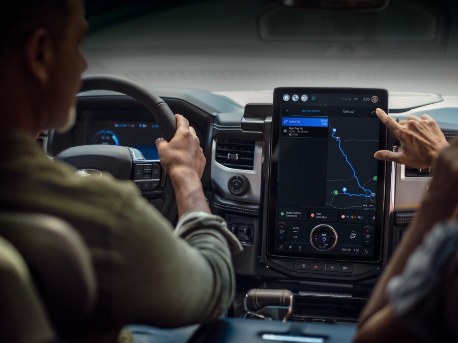 A driver and passenger consult the Navigation app on the Ford F-150 Lightning® touchscreen