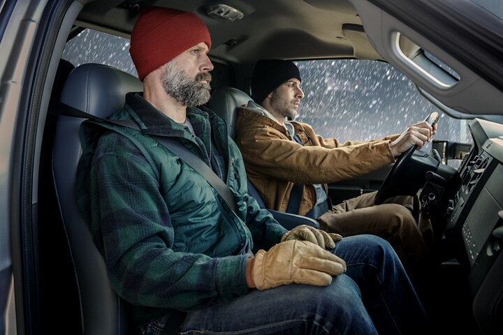 Conductor y pasajero en ropas de invierno en la parte delantera de una Ford F-750 Regular Cab 2024