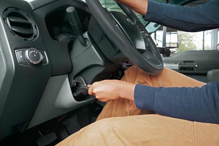 Un conductor ajustando la posición inclinable del volante de una Ford F-750 2024
