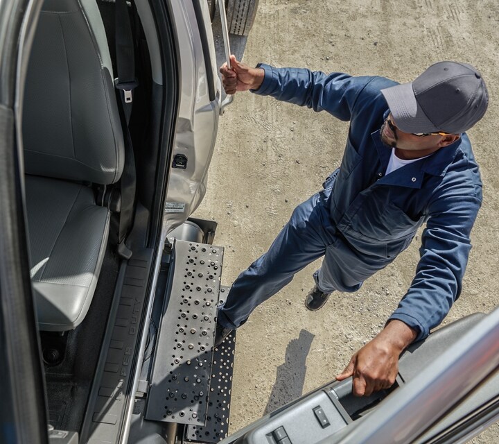 Driver entering 2024 Ford F-750 Regular Cab in Ingot Silver