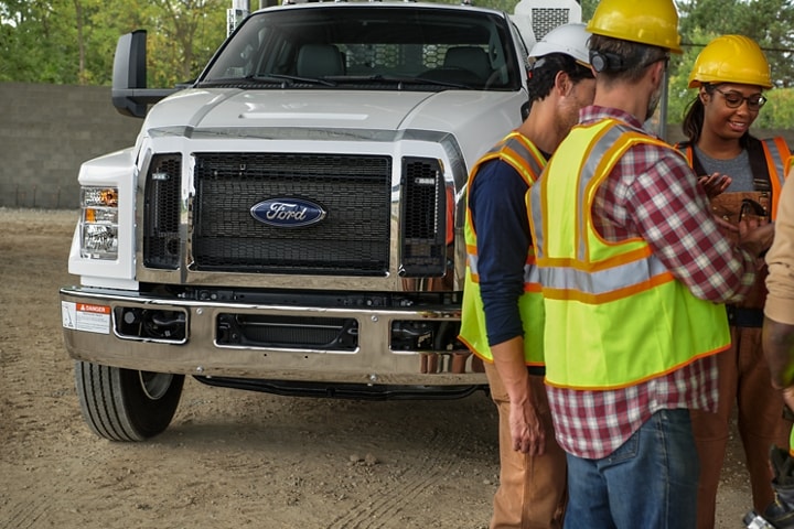 Workers gathered in front of 2024 Ford F-750 SuperCab with mechanic truck upfit in Oxford White