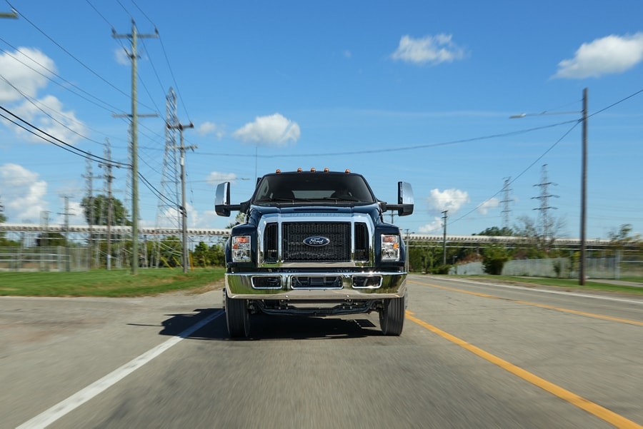 2024 Ford F-750 Crew Cab in Agate Black being driven on road near telephone lines