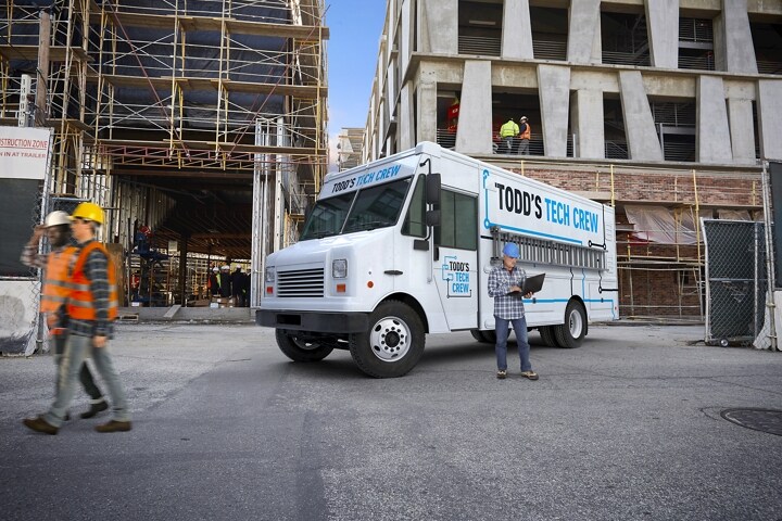 A 2023 Ford F-59 Stripped Chassis with walk-in delivery van body at a construction site